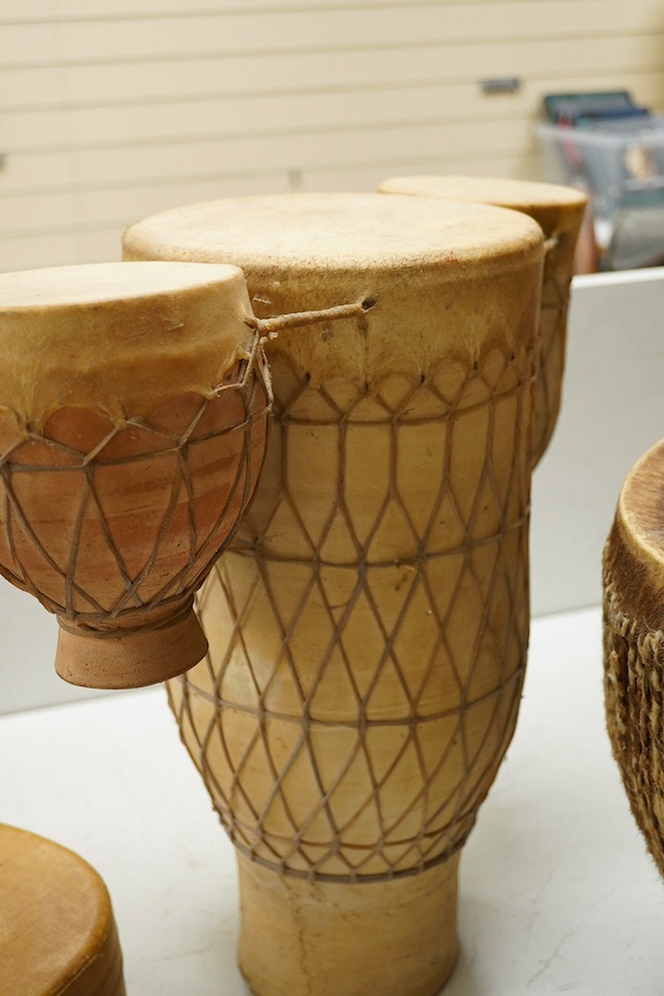 Five African drums; a Djembe, 50cm high, together with four others, including a pottery triple drum, etc. Condition - fair to good.